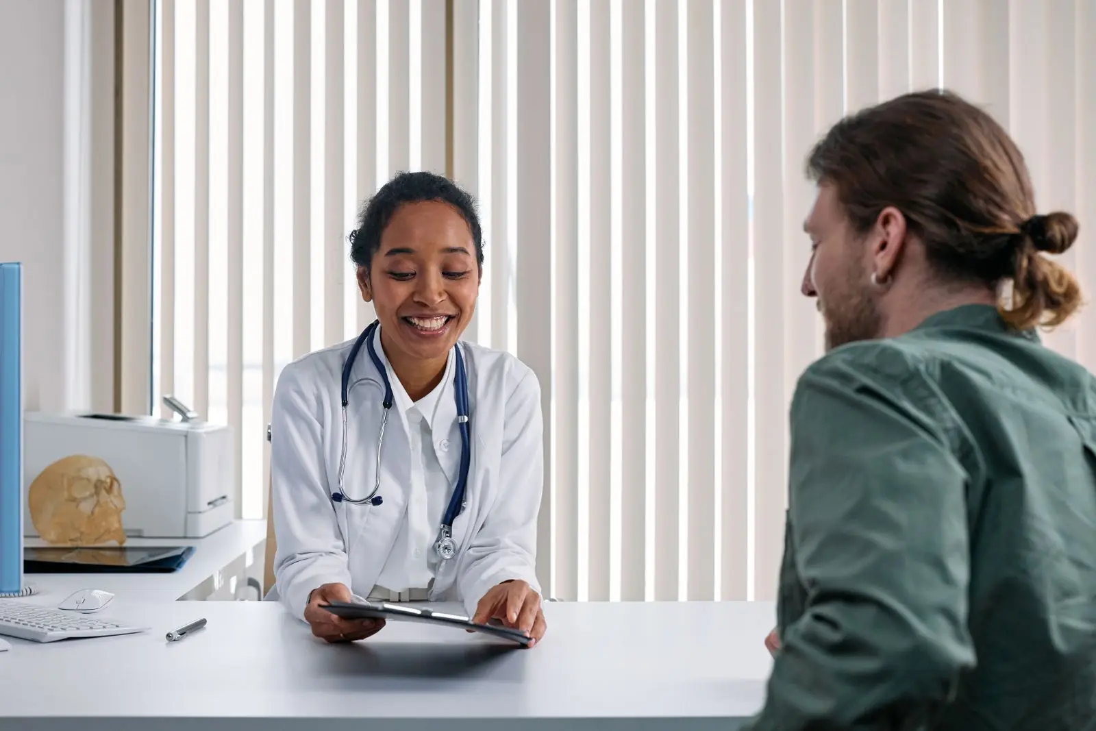 A doctor speaking with a patient in a bright consultation room